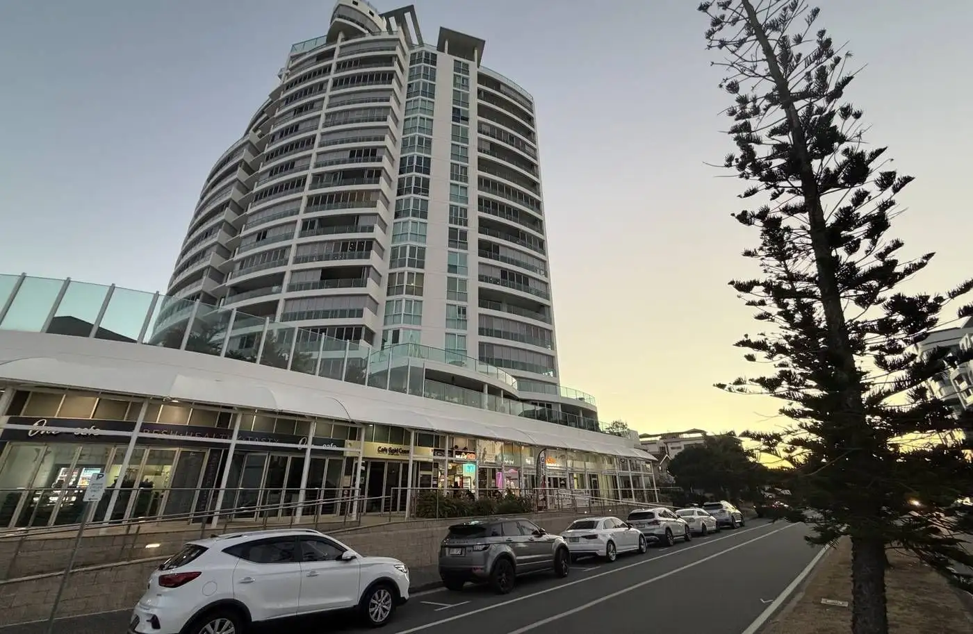 The Aqua tower and its ground-floor shops at dusk, Labrador